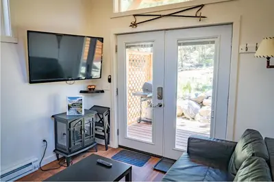 a living room with a couch and a flat screen tv at Skiers Cabin at Base Camp Lodging Company in Dumont