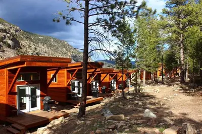 a log cabin in a forest with a mountain at Skiers Cabin at Base Camp Lodging Company in Dumont