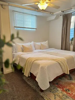 a bedroom with a large white bed with a window at 1920s Inspired Stay-coffee Bar- Cozy-local in Denver
