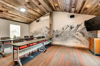 a conference room with a mural of mountains on the wall at A-Lodge Boulder in Boulder