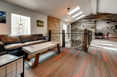 a living room with a leather couch and a table at A-Lodge Boulder in Boulder