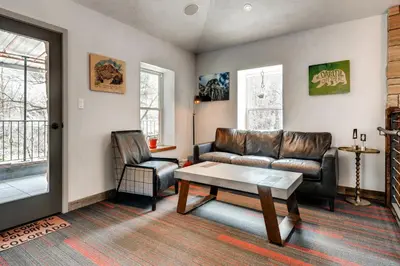 a living room with a leather couch and a chair at A-Lodge Boulder in Boulder