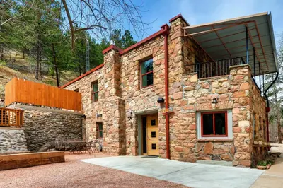 a stone house with a balcony on top of it at A-Lodge Boulder in Boulder