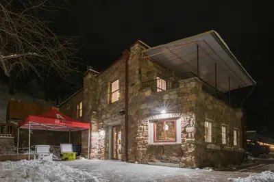 a stone house in the snow at night at A-Lodge Boulder in Boulder