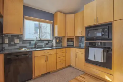 a kitchen with wooden cabinets and a sink and a microwave at 5 bedroom, 7 beds, 3 bath - Sleeps 12, Great for Families in Boulder