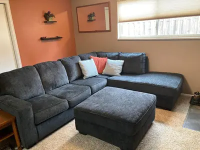 a living room with a blue couch and a ottoman at 5 bedroom, 7 beds, 3 bath - Sleeps 12, Great for Families in Boulder