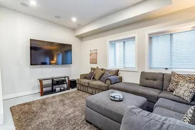 a living room with two couches and a tv at Luxury 5-Bedroom Home in LoHi in Denver