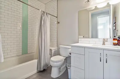 a white bathroom with a toilet and a sink at Luxury 5-Bedroom Home in LoHi in Denver