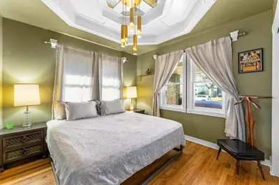 a bedroom with a bed and a window and a chandelier at Epic Mntn views private hot tub and 420 friendly in Denver