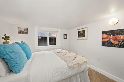 a white bedroom with a bed and a window at Peterson Retreat - Hot Tub, Bikes, Old Town in Fort Collins