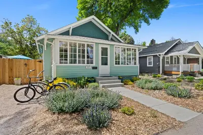 a green house with a bike parked in front of it at Peterson Retreat - Hot Tub, Bikes, Old Town in Fort Collins