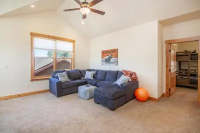 a living room with a blue couch and a ceiling fan at Private Neighborhood Lake, Upscale Quality, 2 Living Rooms, Close to Raven Golf Club in Silverthorne