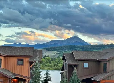 a house with a view of a lake and mountains at Private Neighborhood Lake, Upscale Quality, 2 Living Rooms, Close to Raven Golf Club in Silverthorne