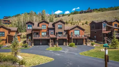 a large house with a mountain in the background at Private Neighborhood Lake, Upscale Quality, 2 Living Rooms, Close to Raven Golf Club in Silverthorne