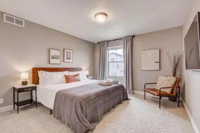a bedroom with a bed and a chair and a window at 5400sqft 6BR 5BA Theater, Office, Game Room in DEN