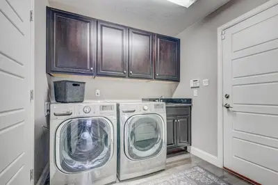 a laundry room with a washer and dryer and cabinets at 5400sqft 6BR 5BA Theater, Office, Game Room in DEN