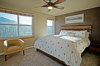 a bedroom with a bed and a ceiling fan at Hot Tub, Blue River in Backyard, Close to 5 Ski Resorts, On Free Bus Route, New Listing in Silverthorne