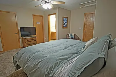 a bedroom with a large bed and a flat screen tv at Hot Tub, Blue River in Backyard, Close to 5 Ski Resorts, On Free Bus Route, New Listing in Silverthorne