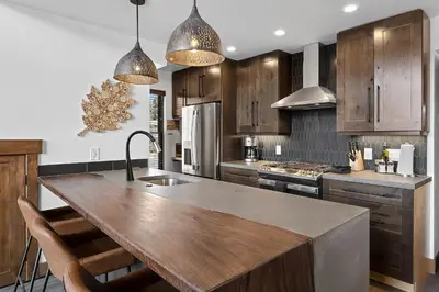 a kitchen with wooden cabinets and a large wooden island at Cabin on Lake Estes! Private Jacuzzi Two Patios Indoor and Outdoor Fireplace in Estes Park