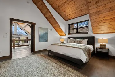 a bedroom with a large bed and a wooden ceiling at Fantastic Views Two Large Patios Private Jacuzzi and Indoor Outdoor Fireplace in Estes Park