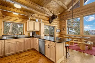 a kitchen with a large island in a log cabin at Mounticello Log Cabin - Relaxing Front Patio & Outdoor Firepit in Estes Park