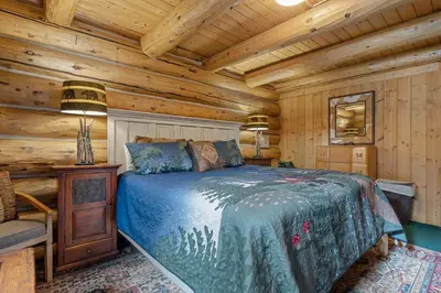 a bedroom with a bed in a log cabin at Mounticello Log Cabin - Relaxing Front Patio & Outdoor Firepit in Estes Park