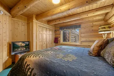 a bedroom with a large bed in a log cabin at Mounticello Log Cabin - Relaxing Front Patio & Outdoor Firepit in Estes Park