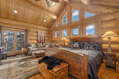 a bedroom with a bed in a log cabin at Mounticello Log Cabin - Relaxing Front Patio & Outdoor Firepit in Estes Park
