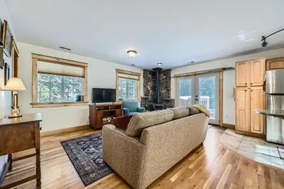 a living room with a couch and a kitchen at Moon Creek Cabin cabin in Nederland