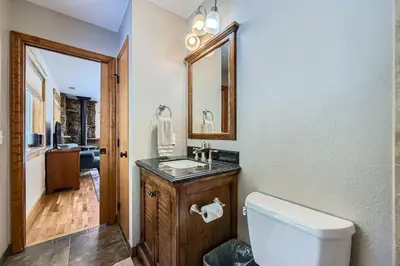 a bathroom with a toilet and a sink and a mirror at Moon Creek Cabin cabin in Nederland