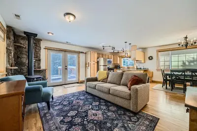 a living room with a couch and a kitchen at Moon Creek Cabin cabin in Nederland