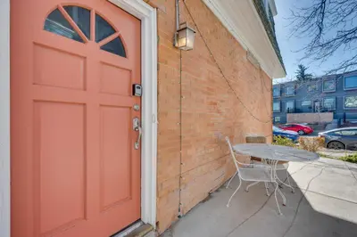 a red door with a table next to a building at 1 Mi to CU Boulder Condo Near Pearl Street! in Boulder