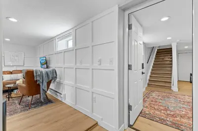 a living room with white walls and a stairway at Urban Hideaway - 2BR - Pets OK - Park 2 Cars - Laundry - Fast WIFI - Close to Everything in Denver