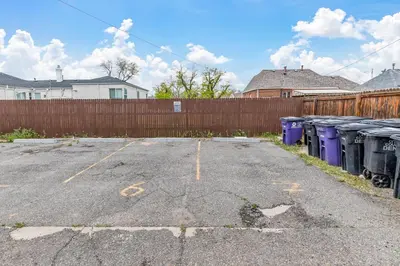 a parking lot with trash cans and a fence at Urban Hideaway - 2BR - Pets OK - Park 2 Cars - Laundry - Fast WIFI - Close to Everything in Denver