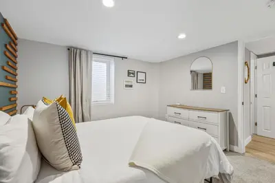 a bedroom with a white bed and a mirror at Urban Hideaway - 2BR - Pets OK - Park 2 Cars - Laundry - Fast WIFI - Close to Everything in Denver