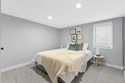 a white bedroom with a bed and a window at Urban Hideaway - 2BR - Pets OK - Park 2 Cars - Laundry - Fast WIFI - Close to Everything in Denver