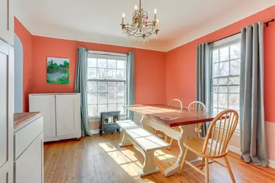 a dining room with orange walls and a wooden table and chairs at Half-Mi to UNC Historic Dtwn Greeley Home in Greeley