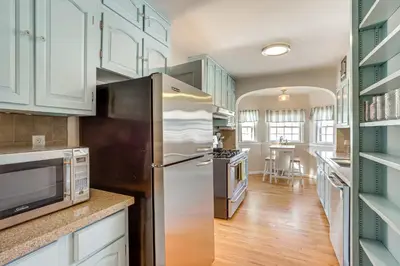 a kitchen with a stainless steel refrigerator and white cabinets at Half-Mi to UNC Historic Dtwn Greeley Home in Greeley