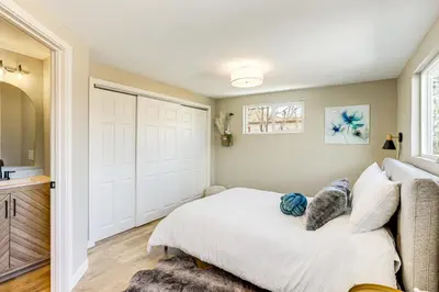 a bedroom with a white bed and a large door at Less Than 1 Mi to Olde Town Arvada Home with Patio! in Arvada