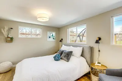 a bedroom with a large white bed and windows at Less Than 1 Mi to Olde Town Arvada Home with Patio! in Arvada