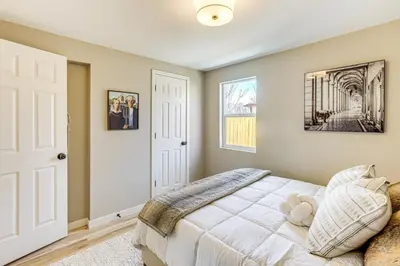 a bedroom with a white bed and a window at Less Than 1 Mi to Olde Town Arvada Home with Patio! in Arvada