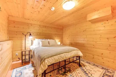a bedroom with a bed in a wooden cabin at 2 Mi to CU Boulder Townhome with Private Deck! in Boulder