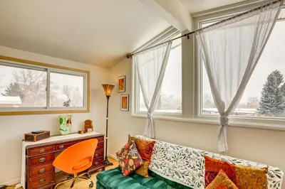 a living room with a couch and two windows at 10 Mi to Red Rocks Denver Home with Fire Pit! in Denver