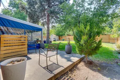 a chair sitting on a patio next to some trees at 10 Mi to Red Rocks Denver Home with Fire Pit! in Denver