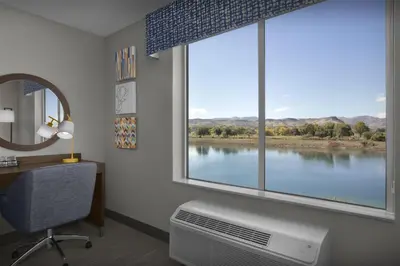 a room with a large window with a desk and a chair at Hampton Inn & Suites By Hilton Wheat Ridge Denver West in Wheat Ridge