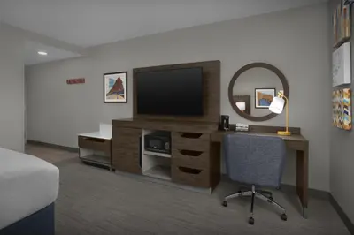 a room with a desk with a television and a chair at Hampton Inn & Suites By Hilton Wheat Ridge Denver West in Wheat Ridge