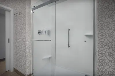 a shower with a glass door in a bathroom at Hampton Inn & Suites By Hilton Wheat Ridge Denver West in Wheat Ridge