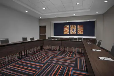 a conference room with a long table and a large screen at Hampton Inn & Suites By Hilton Wheat Ridge Denver West in Wheat Ridge