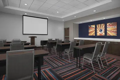 a conference room with tables and chairs and a screen at Hampton Inn & Suites By Hilton Wheat Ridge Denver West in Wheat Ridge