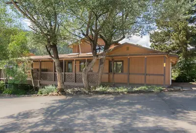 a house with a garage and two trees at Yogi Bear's Jellystone Park Camp-Resort in Estes Park in Estes Park